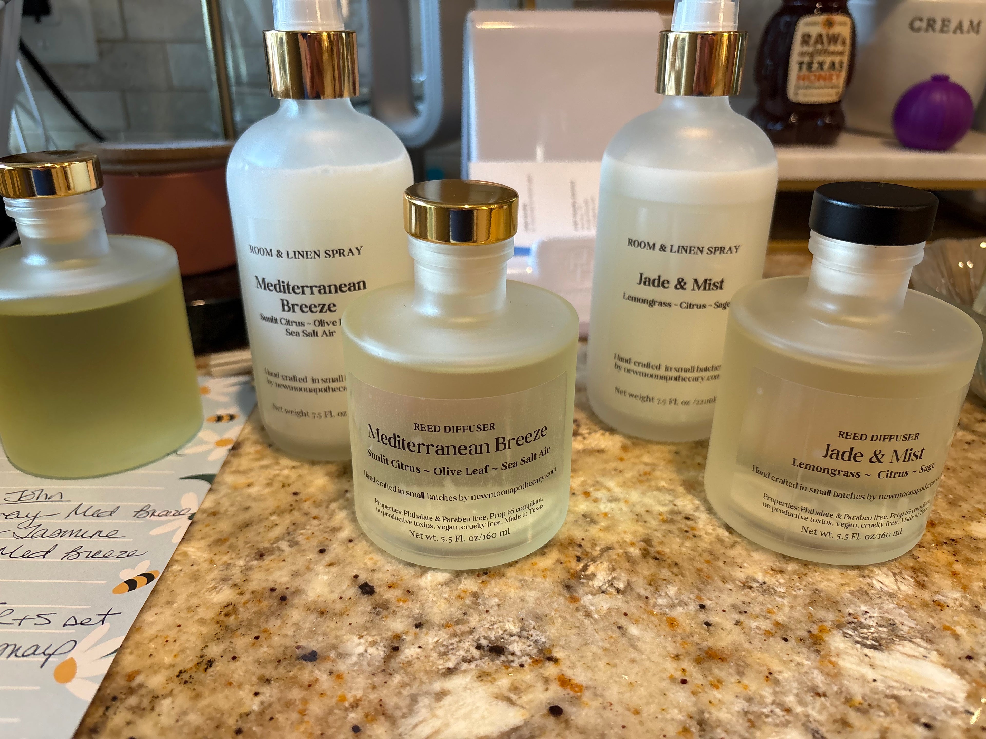 Sacred Space Room & Linen Spray — five bottles during small-batch production on a kitchen counter | New Moon Apothecary