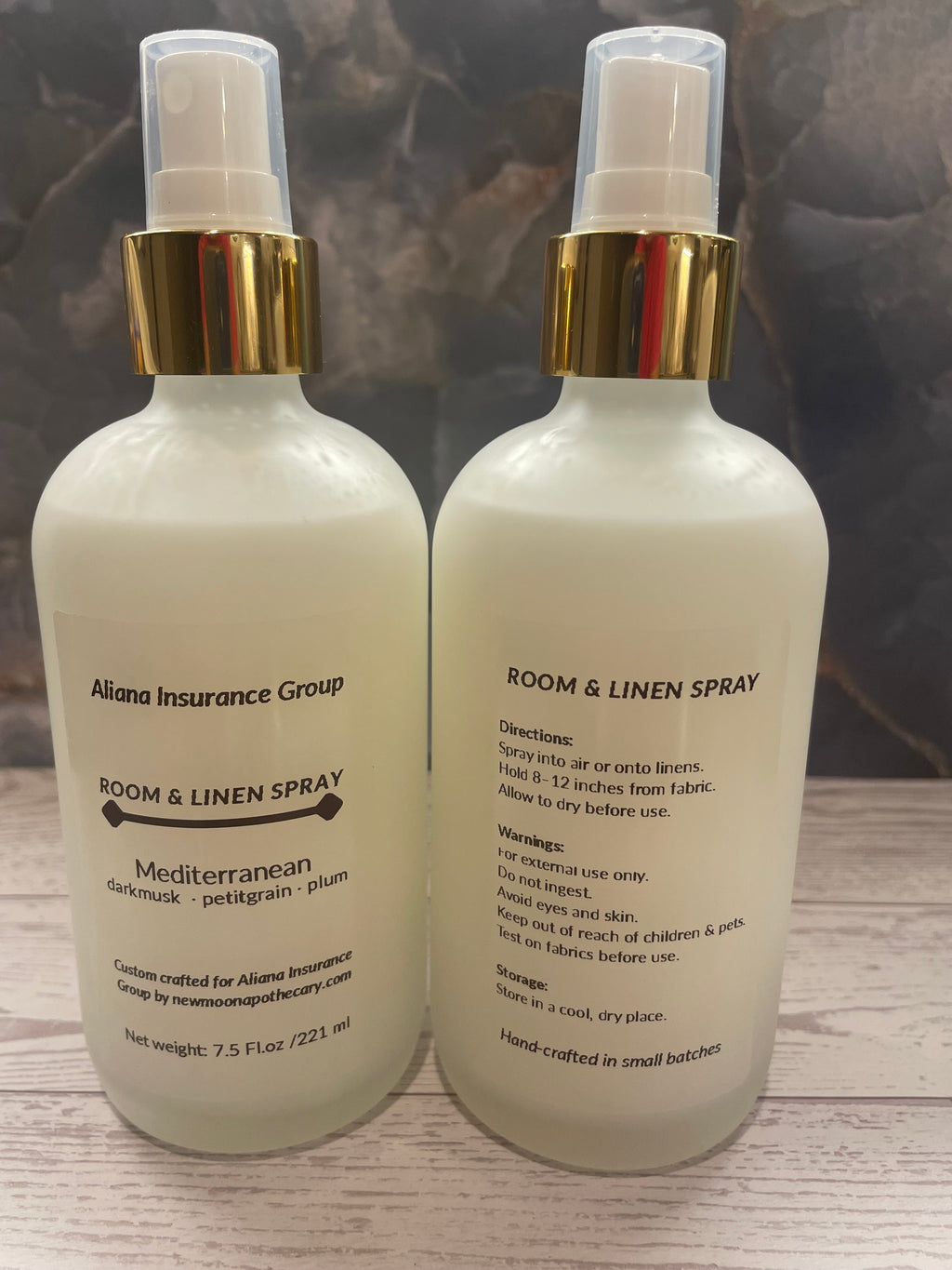 Two bottles of room and linen spray on a wooden surface