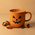 Wicked Pumpkin double-wick candle in a glossy orange jack-o-lantern ceramic mug