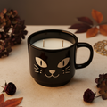 Midnight Mischief double-wick candle in a glossy black cat-face ceramic mug